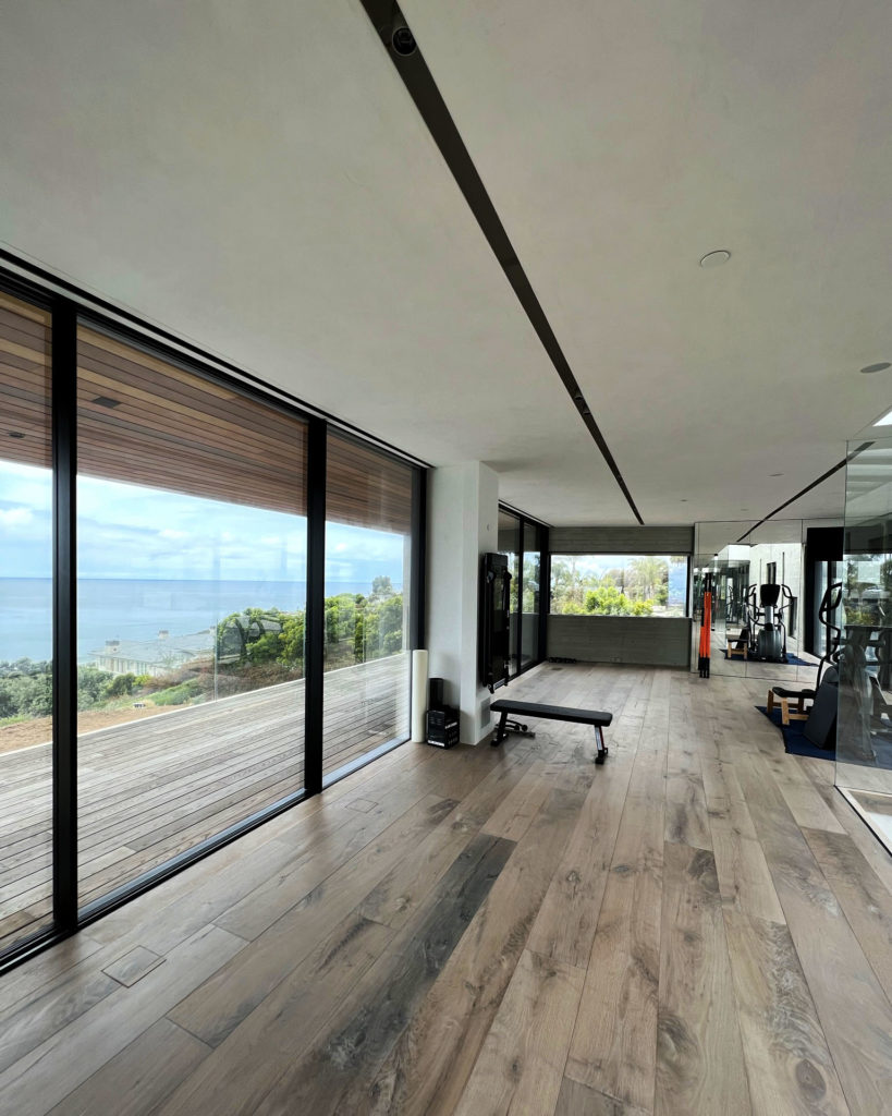 Gym inside Malibu home, heating and cooling is provided by a hydronic system.