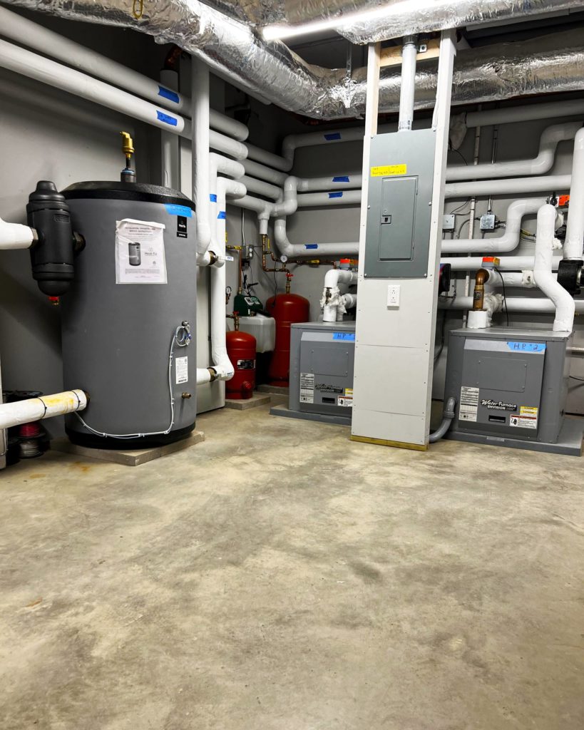 Mechanical room for a geothermal hydronic system that delivers heating and cooling via Ray Magic® NK radiant ceiling panels and Jaga hydronic fan coils.