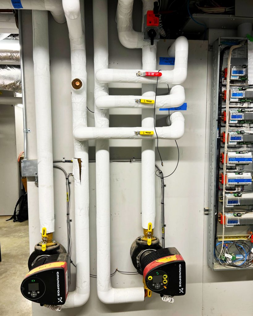 Grundfos pumps in geothermal hydronic system mechanical room.