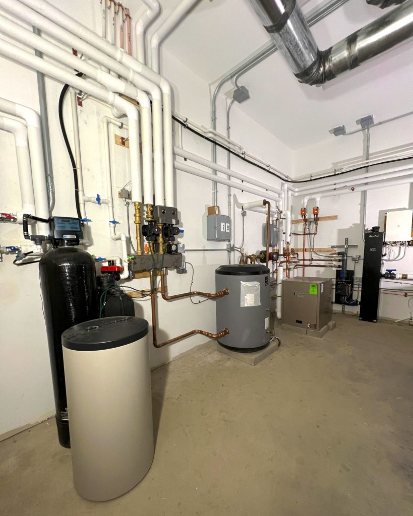Mechanical room for hydronic heating and cooling via radiant floors and hydronic fan coils.