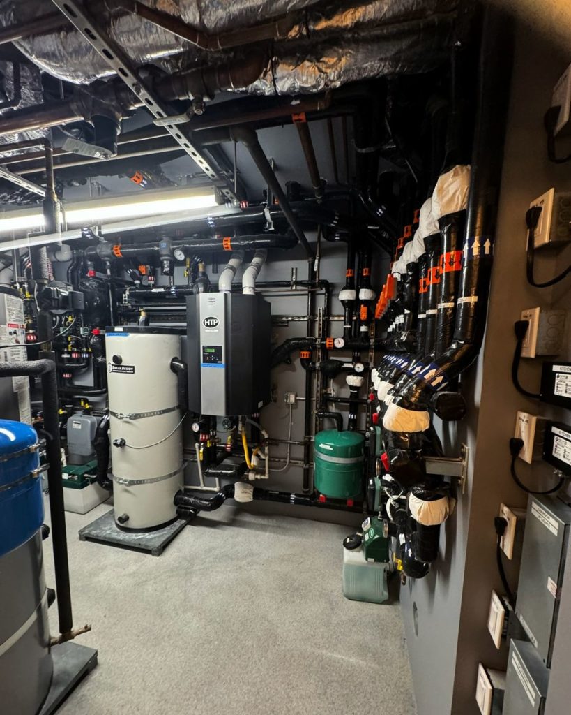 Mechanical room for a home that utilizes a radiant floor, radiant ceiling, and hydronic fan coils.