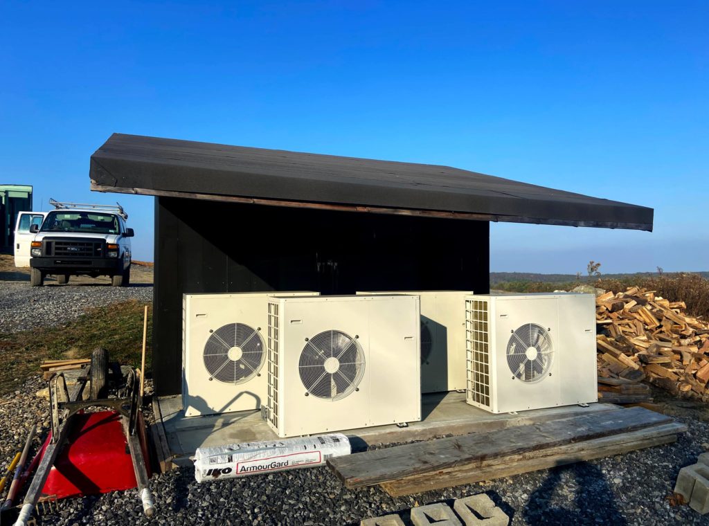 Four air-to-water heat pumps for a hydronic system that utilizes fan coils and a radiant floor.